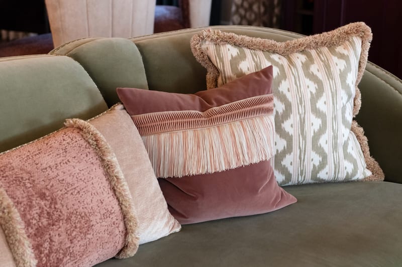 Layered cushions and throws on a sofa