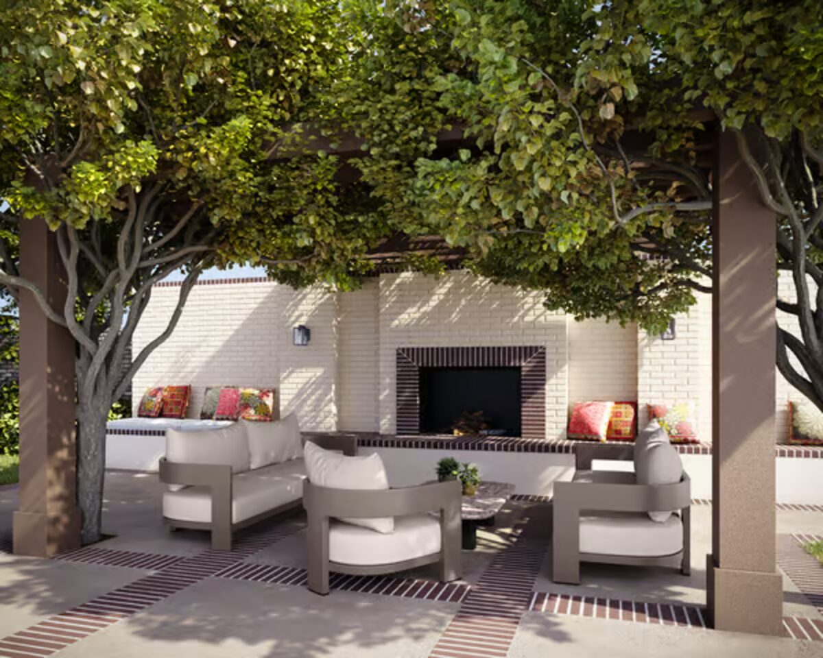 A Tobias Oliver outdoor terrace with pergola seating and a fireplace